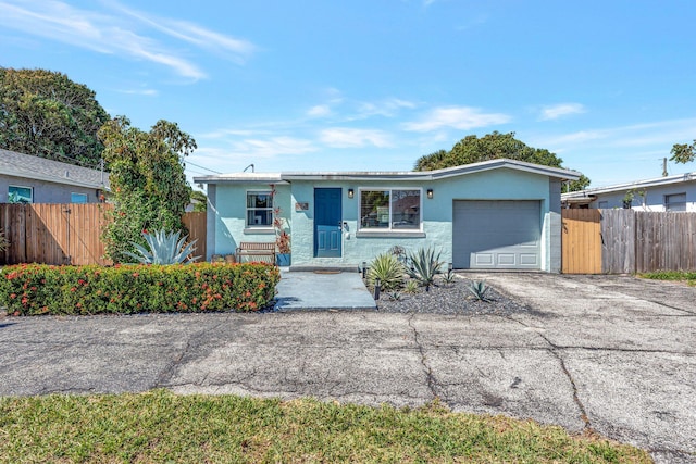 ranch-style home with fence, an attached garage, and stucco siding