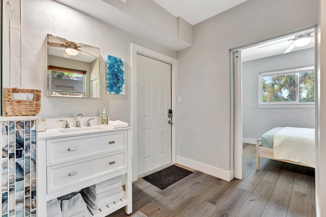 bathroom featuring a ceiling fan, vanity, baseboards, and wood finished floors