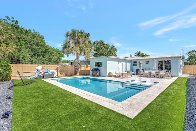 view of swimming pool with a fenced in pool, a patio, a fenced backyard, a yard, and an outdoor living space