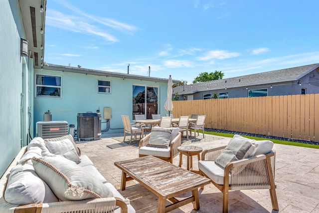 view of patio with cooling unit, fence, outdoor dining space, and an outdoor hangout area