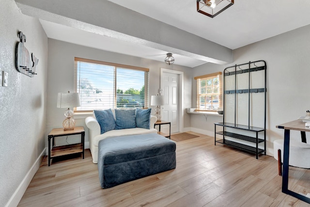 living area with a textured wall, wood finished floors, and baseboards