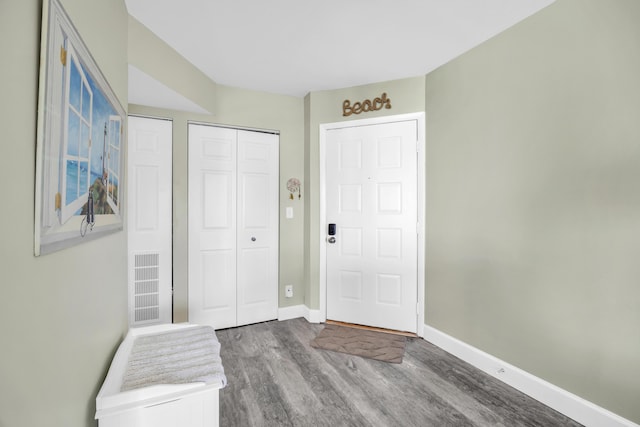 foyer with visible vents, baseboards, and wood finished floors