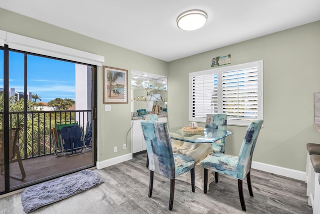 dining room featuring plenty of natural light, baseboards, and wood finished floors