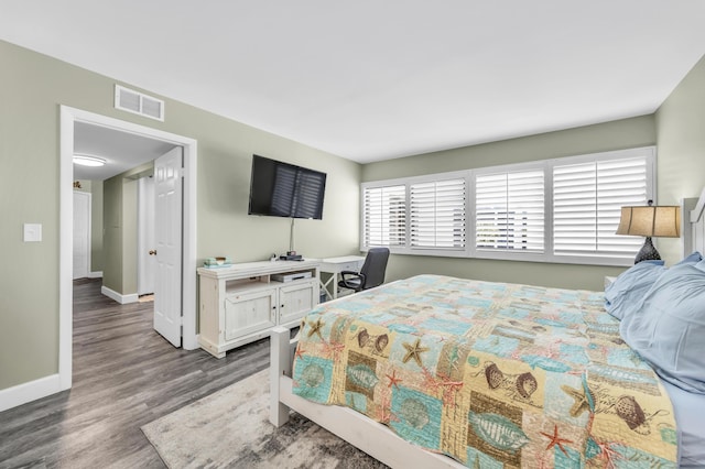 bedroom featuring visible vents, baseboards, and wood finished floors