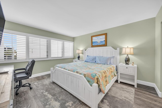 bedroom featuring baseboards and wood finished floors