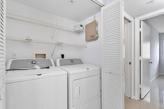 washroom featuring laundry area, baseboards, and washing machine and clothes dryer