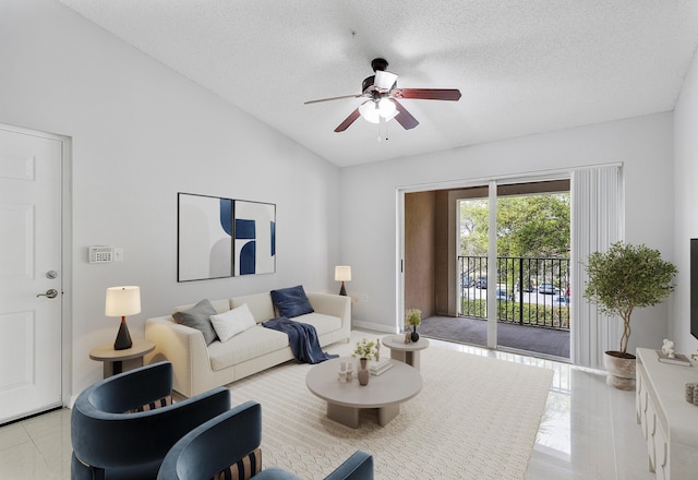 living area featuring a ceiling fan, lofted ceiling, a textured ceiling, and baseboards