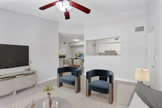 living room featuring baseboards, visible vents, ceiling fan, and tile patterned flooring