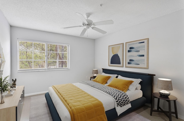 bedroom with ceiling fan, a textured ceiling, and baseboards