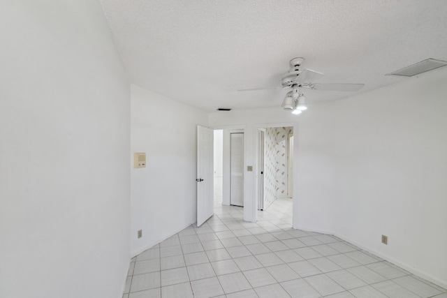 spare room featuring a ceiling fan, visible vents, and a textured ceiling