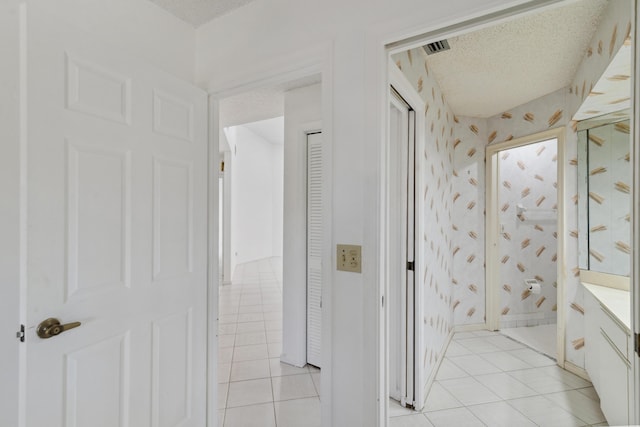 bathroom featuring tile patterned flooring, a textured ceiling, vanity, and wallpapered walls