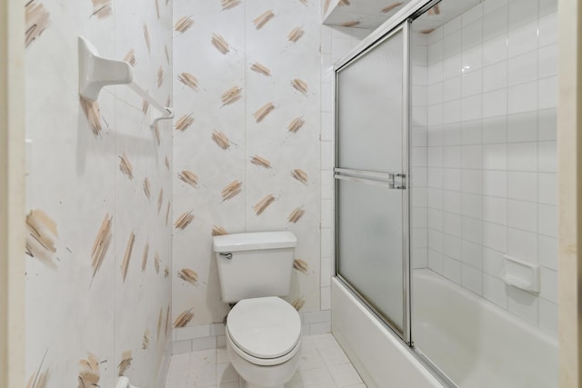 full bath with combined bath / shower with glass door, tile patterned flooring, toilet, and wallpapered walls