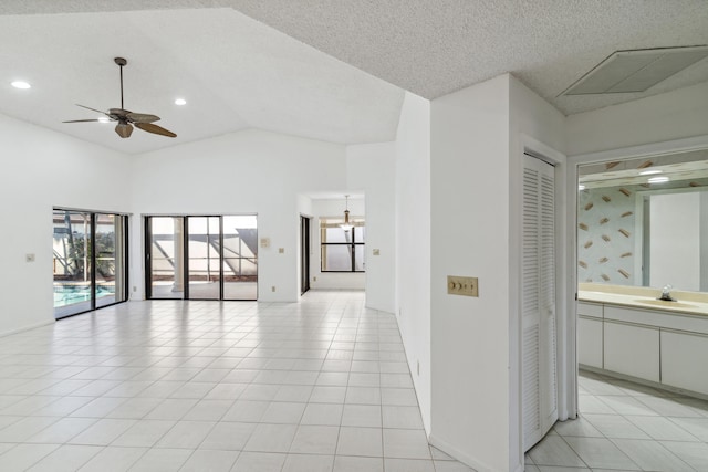 unfurnished room with light tile patterned floors, visible vents, lofted ceiling, ceiling fan, and a sink