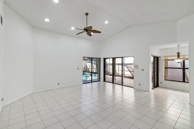 empty room featuring light tile patterned floors, recessed lighting, ceiling fan, high vaulted ceiling, and baseboards