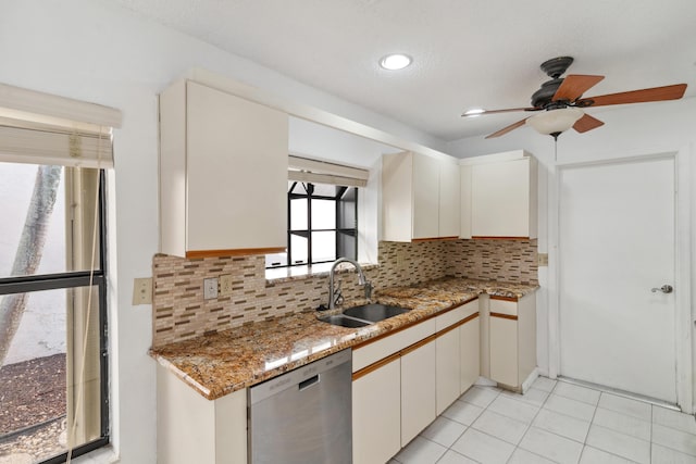 kitchen featuring light tile patterned floors, a sink, light stone countertops, dishwasher, and tasteful backsplash