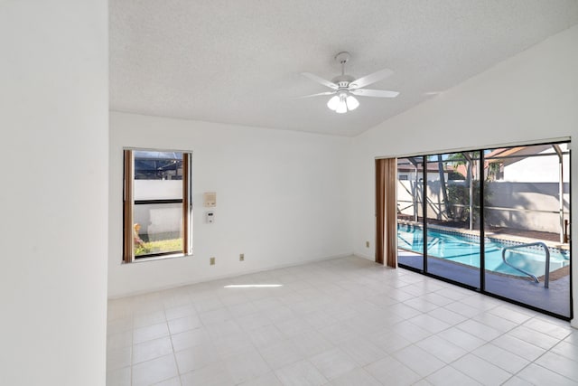 unfurnished room featuring lofted ceiling, ceiling fan, and a textured ceiling