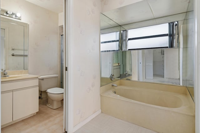 bathroom featuring toilet, baseboards, a bath, and vanity