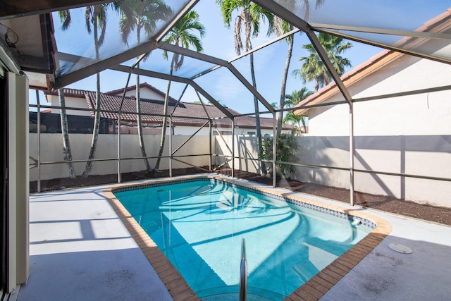 view of swimming pool featuring glass enclosure, a patio area, and a fenced in pool