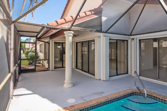 view of patio with a lanai, a ceiling fan, and an outdoor pool