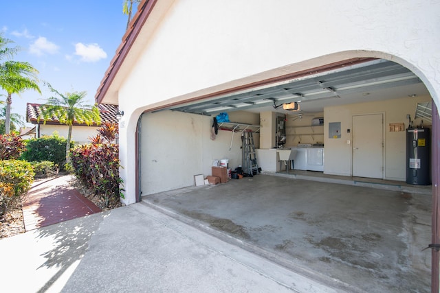 garage featuring a garage door opener, electric panel, water heater, and washer and clothes dryer