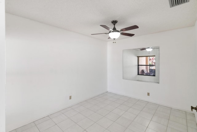 empty room featuring a ceiling fan, visible vents, and a textured ceiling