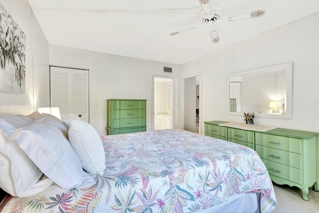 bedroom featuring visible vents, a ceiling fan, connected bathroom, light colored carpet, and a closet