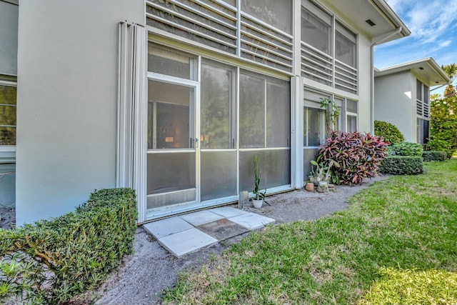 view of side of home with stucco siding and a yard