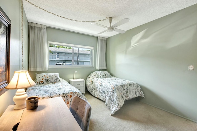 bedroom featuring carpet floors, a textured ceiling, and a ceiling fan