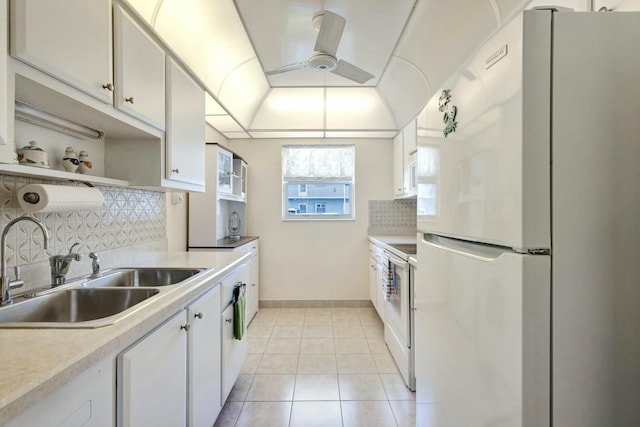 kitchen with light tile patterned floors, backsplash, white cabinetry, a sink, and white appliances