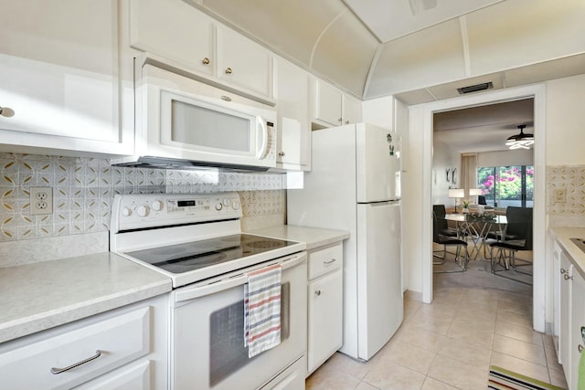 kitchen with light countertops, white appliances, light tile patterned flooring, and tasteful backsplash