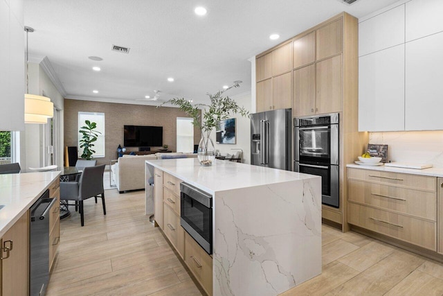 kitchen featuring appliances with stainless steel finishes, modern cabinets, light brown cabinets, and visible vents