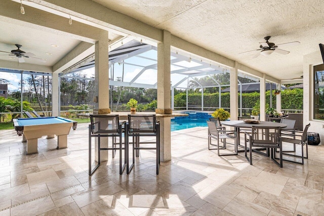 view of patio featuring a pool with connected hot tub, outdoor dining area, a lanai, and a ceiling fan