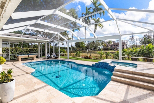 pool with a lanai, a patio area, and an in ground hot tub