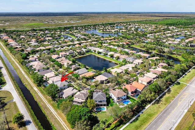 birds eye view of property with a water view and a residential view