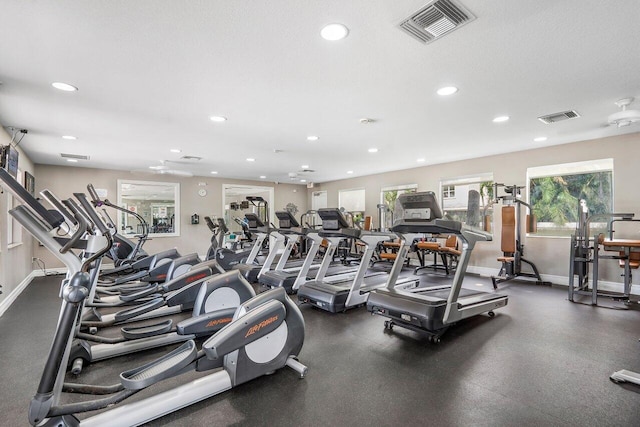 gym with a textured ceiling, recessed lighting, visible vents, and baseboards