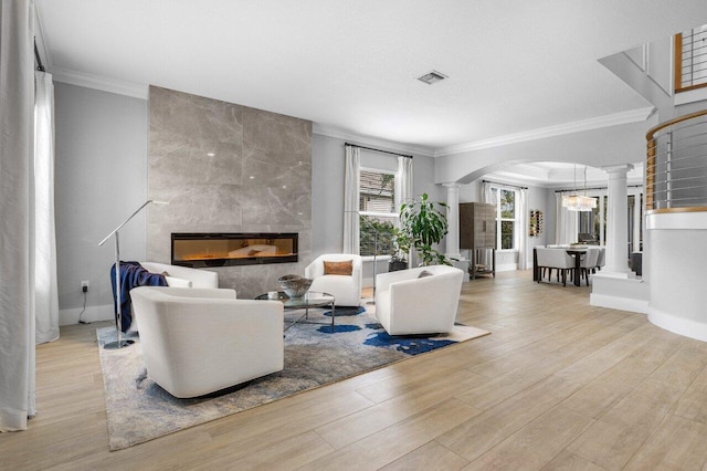 living room with ornate columns, a fireplace, visible vents, and arched walkways