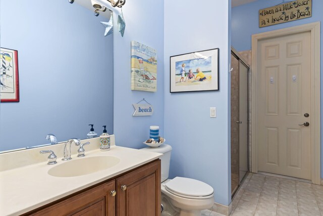 bathroom with vanity, a shower stall, and toilet