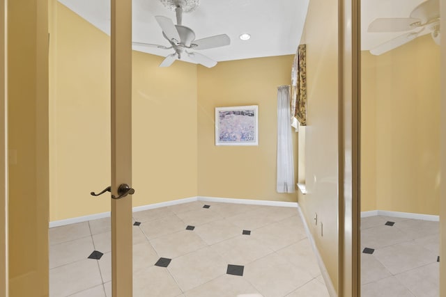 interior space with light tile patterned flooring, baseboards, and ceiling fan