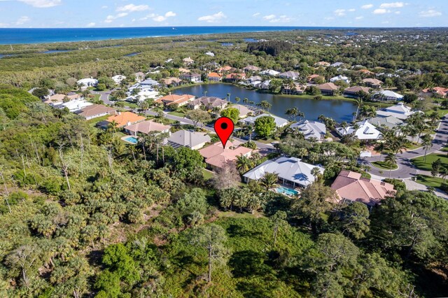 drone / aerial view featuring a residential view, a forest view, and a water view