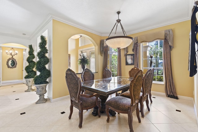 dining area featuring light tile patterned floors, baseboards, arched walkways, and ornamental molding