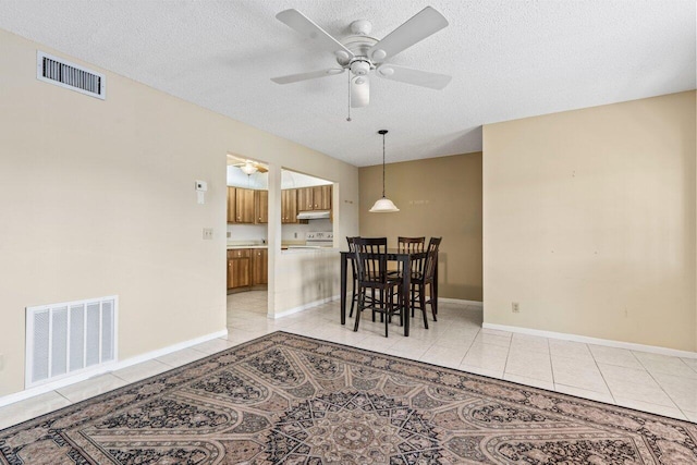 dining area featuring light tile patterned floors, a textured ceiling, and visible vents