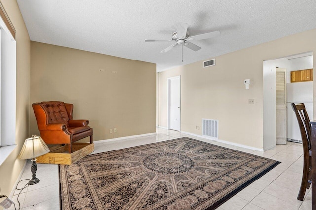 sitting room featuring light tile patterned floors, visible vents, and a textured ceiling