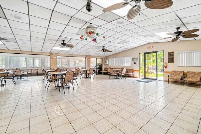 unfurnished dining area with a paneled ceiling, light tile patterned floors, and vaulted ceiling