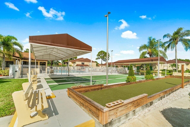 view of community featuring shuffleboard and fence