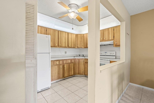 kitchen with light countertops, light tile patterned flooring, a sink, white appliances, and under cabinet range hood