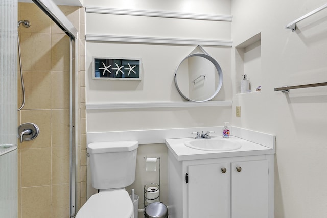 full bathroom featuring a stall shower, vanity, and toilet