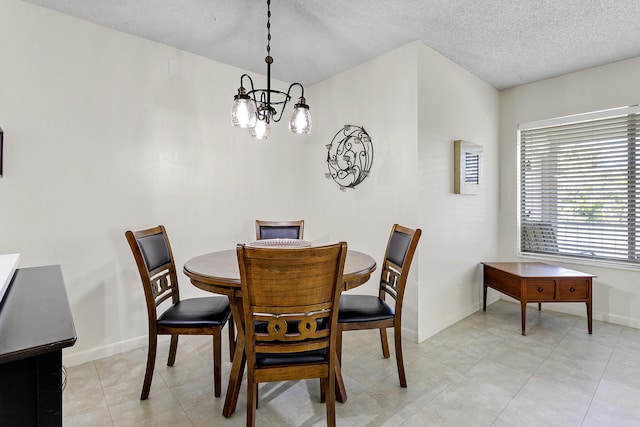 dining area featuring a notable chandelier, a textured ceiling, baseboards, and light tile patterned floors