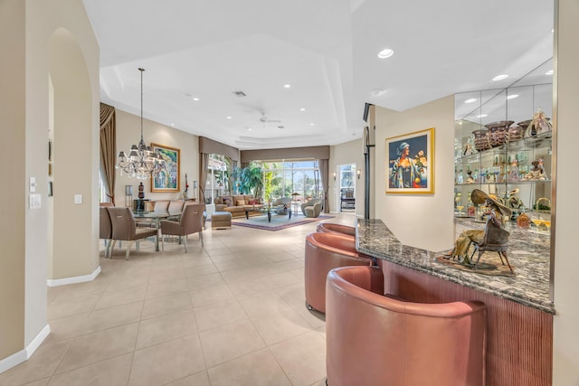 interior space with light tile patterned floors, recessed lighting, hanging light fixtures, baseboards, and ceiling fan with notable chandelier