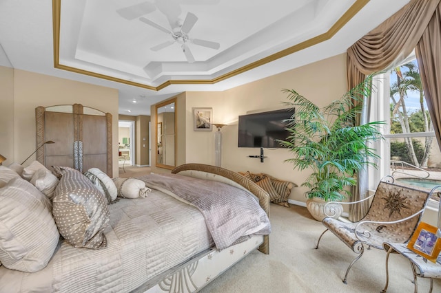 bedroom featuring a ceiling fan, a tray ceiling, carpet flooring, and baseboards