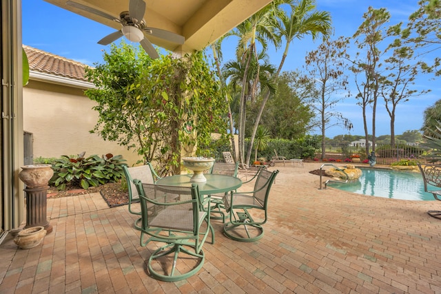 view of patio / terrace with a fenced in pool, outdoor dining space, a fenced backyard, and ceiling fan